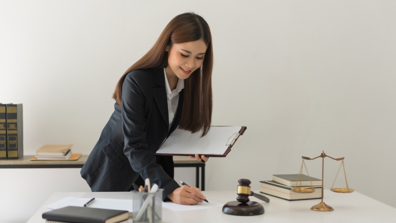 Ilustrasi konsep PSAK 24 dan SAK ETAP, mewujudkan optimalisasi dalam akuntansi imbalan kerja. Law concept, Female lawyer is writing contract about legal regulations and working in law firm